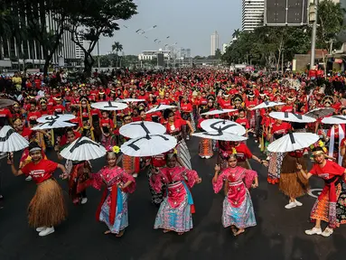 Penari menampilkan tarian khas Indonesia saat car free day (CFD) di Jalan Sudirman, Jakarta, Minggu (4/8/2019). Sebanyak 2.000 penari menampilkan 10 tarian khas Indonesia untuk menyatukan masyarakat yang sempat terpecah belah sehabis Pemilu 2019. (Liputa6.com/JohanTallo)