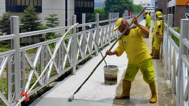 Petugas mengecat JPO tanpa atap di Jalan Sudirman, Jakarta Rabu (6/11/2019).