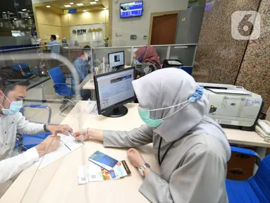 Nasabah Unit Usaha Syariah (UUS) PT Bank Tabungan Negara (Persero) Tbk. tengah melakukan transaksi di kantor BTN Syariah di Jakarta, Rabu (06/04/2021). BTN Syariah tetap mencatatkan pertumbuhan kinerja mencapai double digit kendati berada di masa pandemi. (Liputan6.com/Pool/BTN)