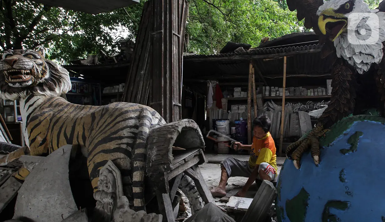 Perajin membuat patung berbahan dasar batu alam di Sanggar Dunia Batu Alam, Jakarta, Senin (5/12/2020). Sebelum pandemi Covid-19 perajin batu alam mengaku mendapatkan omzet Rp200 juta - Rp300 juta sebulan, namun kini hanya mampu mengantongi Rp30 juta - Rp50 juta sebulan. (merdeka.com/Imam Buhori)
