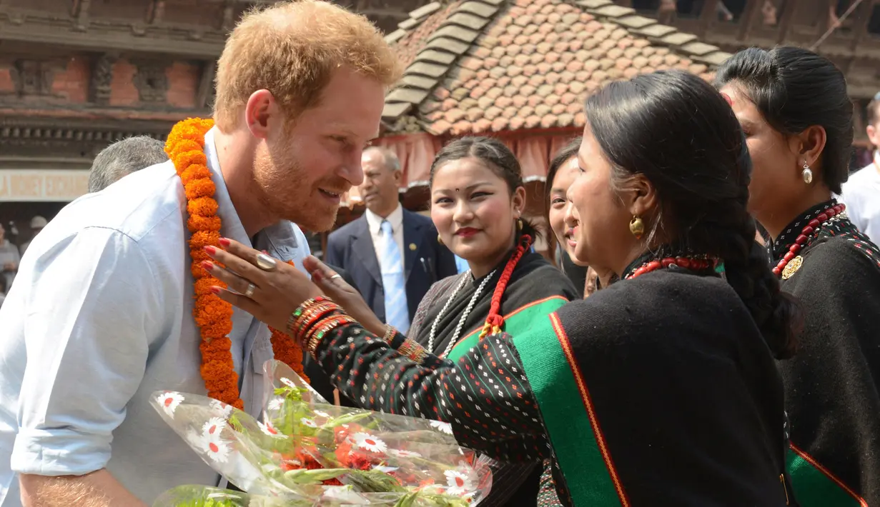 Panchakanya atau lima perawan khas budaya tradisional Nepal menyambut kedatangan Putra Mahkota Kerajaan Inggris, Pangeran Harry,  saat mengunjungi salah satu situs warisan Patan Durbar Square di Kathmandu, Minggu (20/3). (REUTERS/Prakash Mathema/Pool)