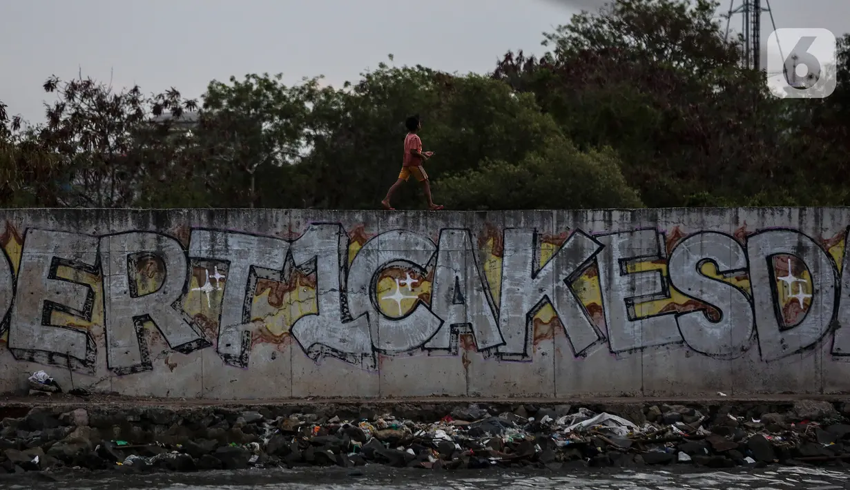 Seorang anak bermain di pelabuhan sunda kelapa, Jakarta, Kamis (12/8/2021). Kegiatan bermain dipinggir dan berenang air laut ini merupakan bagian dari keseharian mereka mengisi waktu kosong diluar jam sekolah. (Liputan6.com/Johan Tallo)