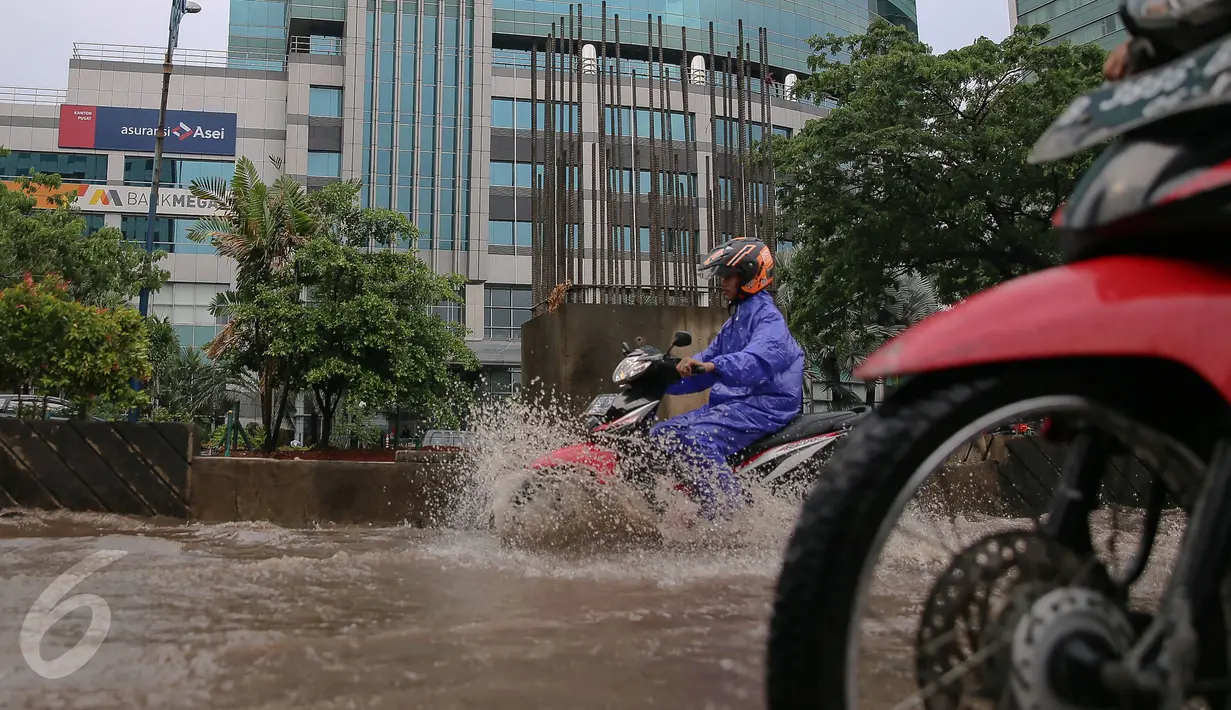Pengendara motor melewati genangan air di kawasan Kuningan, Jakarta, Selasa (24/11). Jalur lambat di Jalan HR Rasuna Said, Kuningan, tampak dihindari pengendara karena terdapat genagan air setinggi 20 cm. (Liputan6.com/Faizal Fanani)