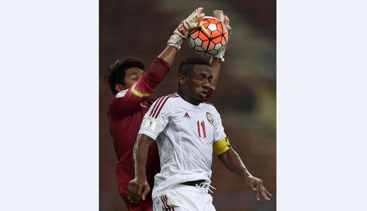 Kiper Malaysia, Mohd Izham Tarmizi (kiri), berusaha mengamankan bola dari pemain UEA, Ahmed Khalil, dalam Kualifikasi Piala Dunia 2018 di Stadion Shah Alam, Malaysia, (17/11/2015). Malaysia kalah 1-2 dari UEA. (AFP Photo/Manan Vatsyayana)