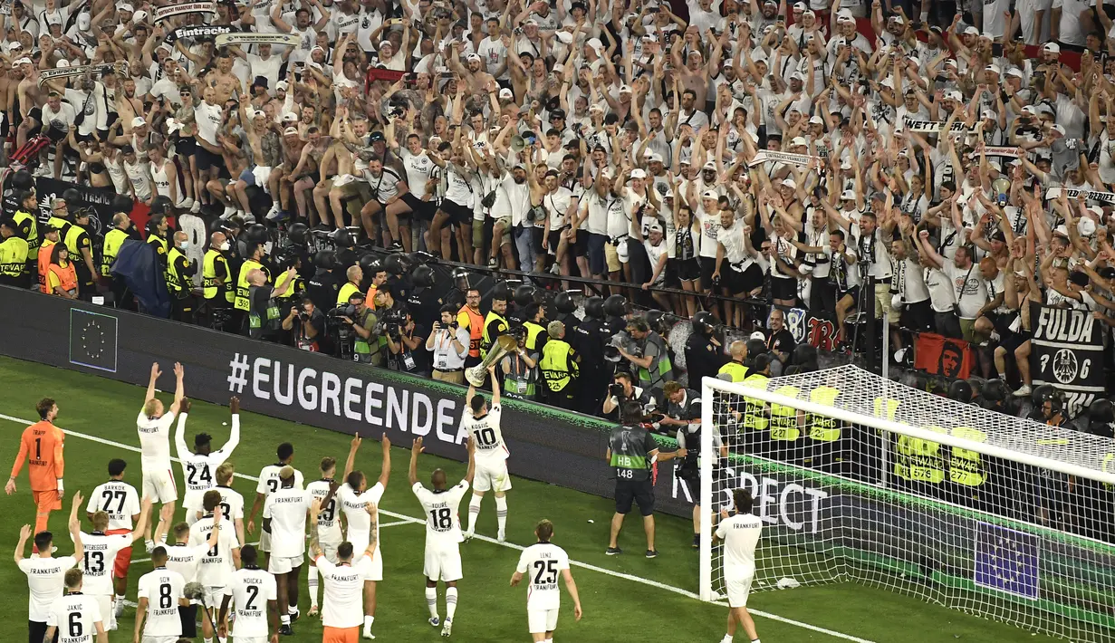 Para pemain Frankfurt merayakan dengan trofi setelah memenangkan pertandingan final Liga Europa melawan Rangers di stadion Ramon Sanchez Pizjuan di Seville, Spanyol, Kamis (19/5/2022). Frankfurt mengalahkan Rangers 5-4 dalam adu penalti setelah pertandingan pertandingan berakhir imbang 1-1. (AP Photo/Jose Breton)