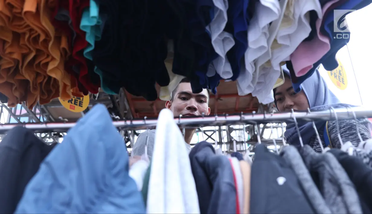 Pengunjung memilih koleksi pakaian di salah satu stand pada gelaran JakCloth di halaman Istora Senayan, Jakarta, Senin (4/6). Beragam merek pakaian anak muda dihadirkan pada gelaran yang berlangsung hingga 10 Juni 2018. (Liputan6.com/Helmi Fithriansyah)