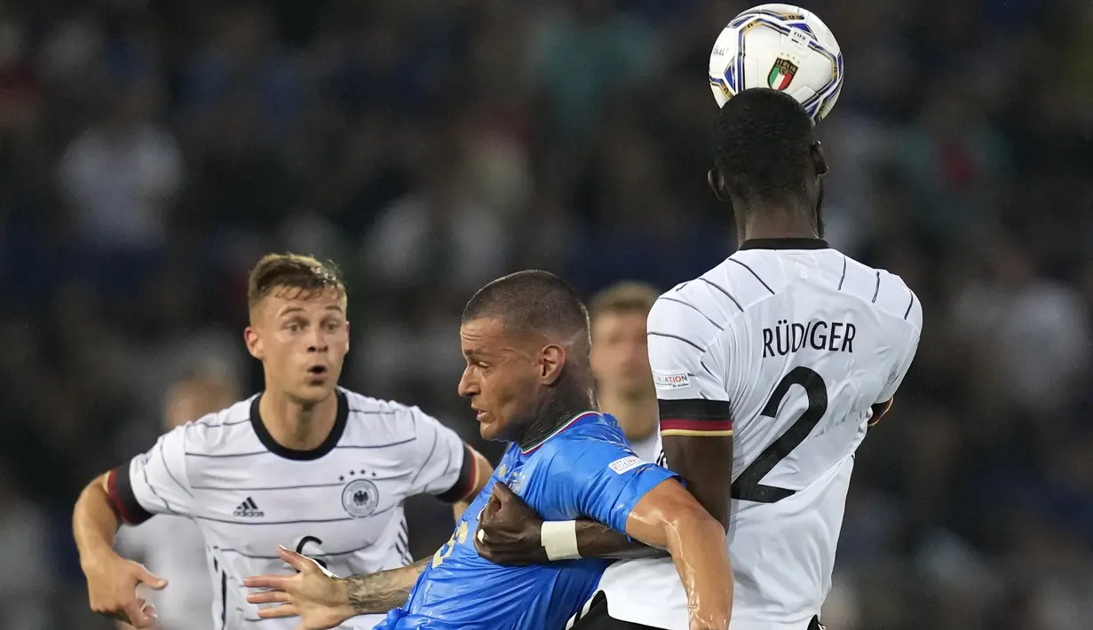 Penyerang timnas Italia Gianluca Scamacca (tengah) berebut bola dengan bek Jerman Antonio Rudiger pada matchday pertama UEFA Nations League A Grup 3 di Renato Dall'Ara, Minggu (6/5/2022) dini hari WIB. Jerman bermain imbang melawan Italia dengan skor 1-1. (AP Photo/Antonio Calanni)