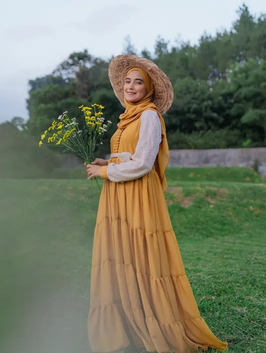 Dikabarkan sedang hamil, paras Nadya Mustika dalam pemotretan tema kebun ini begitu memesona. Dengan balutan dress berwarna mustard ia tampak begitu anggun dan cantik. Senyumnya yang khas juga berhasil curi perhatian. (Liputan6.com/IG/@nadyamustikarahayu)