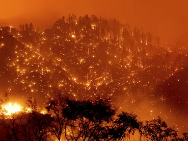 Dalam foto eksposur panjang ini menunjukkan bara api menyala pada lereng bukit saat Dixie Fire membakar dekat Milford di Lassen County, California, Amerika Serikat, Selasa (17/8/2021). Kebakaran hutan mengancam untuk menyebarkan ke beberapa wilayah di California utara. (AP Photo/Noah Berger)