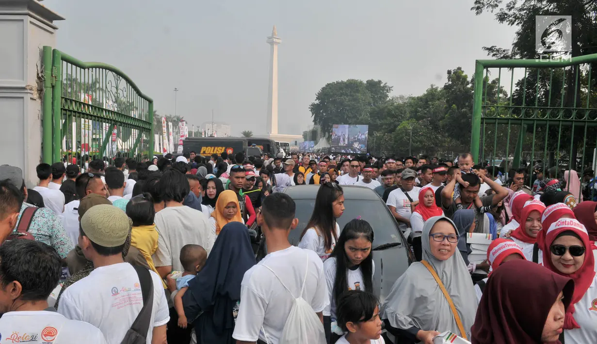 Kepadatan warga saat menghadiri Festival Damai Millenial Road Safety di kawasan Monumen Nasional (Monas), Jakarta, Minggu (23/6). Festival ini untuk menyosialisasikan disiplin berlalu lintas serta merajut persatuan dan kesatuan, khususnya generasi milienial. (merdeka.com/Iqbal Nugroho)