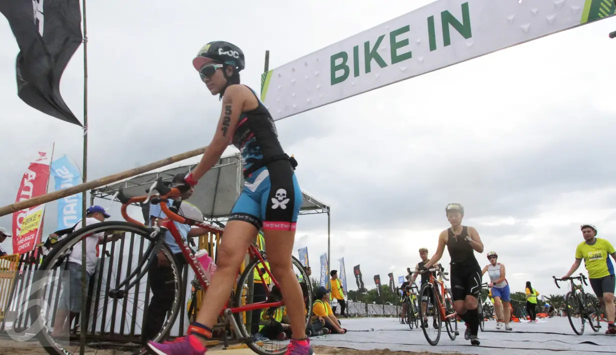 Peserta bersiap menaiki sepeda setelah berenang di pantai sepanjang 1,5 km pada Herbalife Bali International Triathlon 2016 di Sanur, Bali, Minggu (14/8). (Liputan6.com/Made Anto)