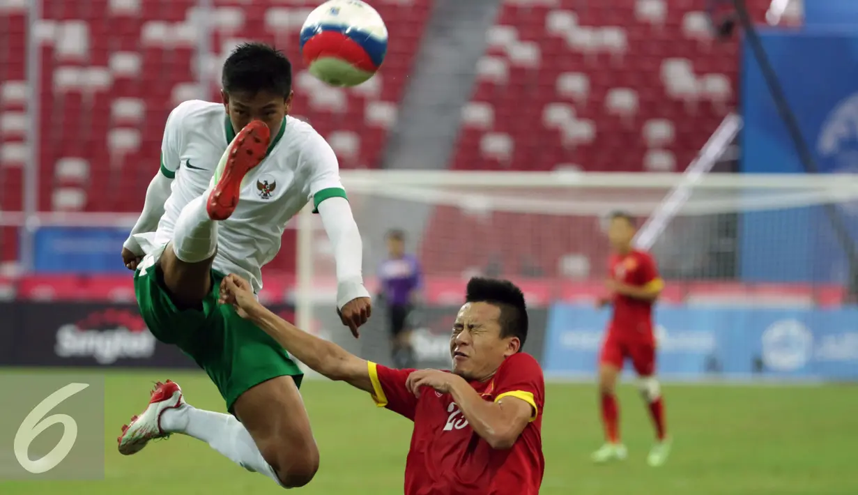 Bek Indonesia U-23, Syaiful Indra Cahya (kiri) membuang bola yang mengarah ke Huy Toan Vo (Vietnam) diperebutan tempat ketiga Sepak Bola SEA Games 2015 di National Stadium Singapura, (15/6/2015). Indonesia kalah 0-5. (Liputan6.com/Helmi Fithriansyah)