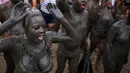 Peserta dengan tubuh yang dipenuhi lumpur menari saat mengikuti festival tradisional "Bloco da Lama" atau "Mud Street" di Paraty, Brasil (25/2). Festival ini diikuti mulai dari masyarakat sekitar sampai turis asing. (AP Photo / Mauro Pimentel)