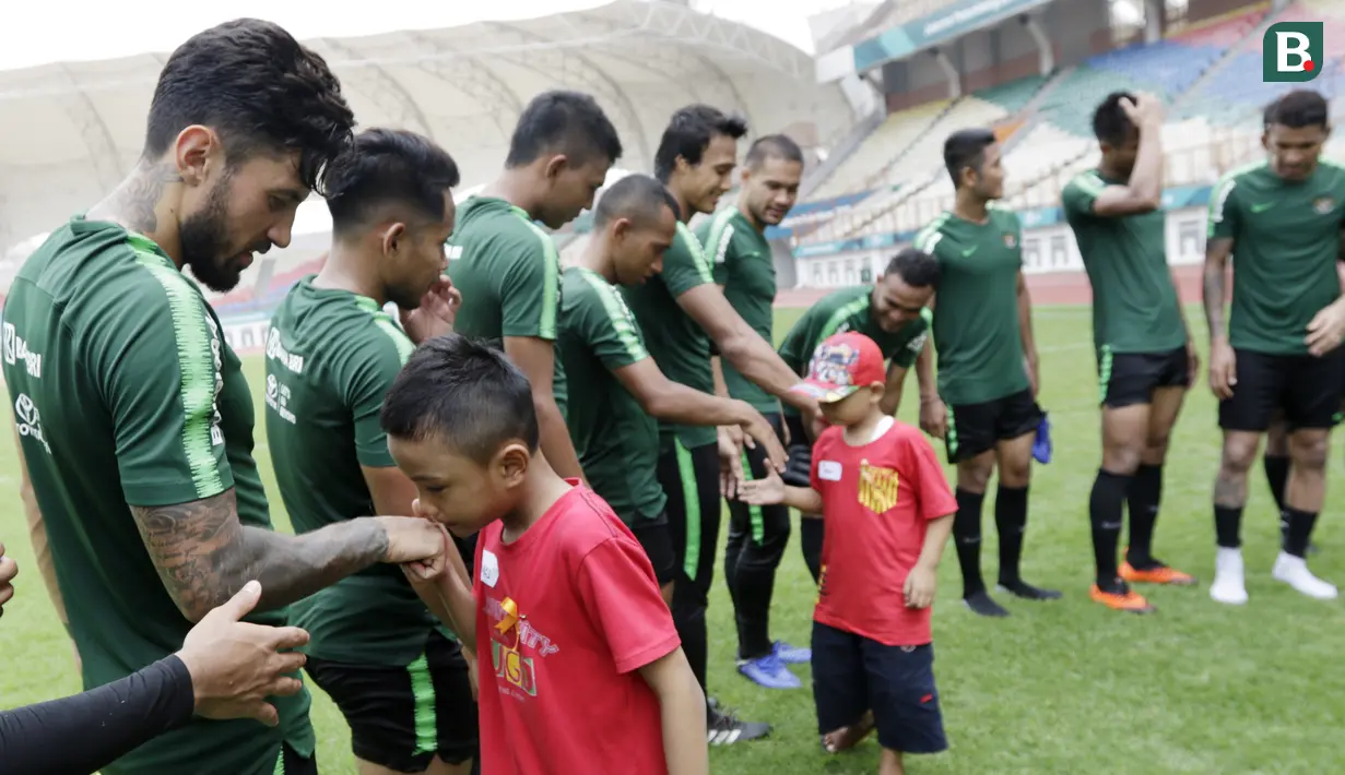 Pemain Timnas Indonesia berjumpa dengan anak-anak pasien kanker saat latihan di Stadion Wibawa Mukti, Jawa Barat, Senin (5/11). Pemusatan latihan Timnas ini merupakan persiapan jelang Piala AFF 2018. (Bola.com/M Iqbal Ichsan)