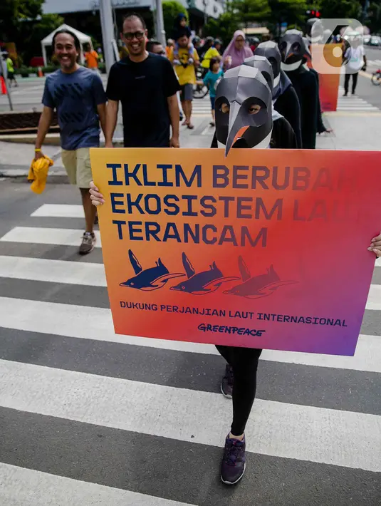 Sejumlah aktivis Greenpeace mengenakan topeng penguin saat menggelar aksi dalam car free day di kawasan Thamrin, Jakarta, Minggu (9/2/2020). Mereka mengajak pemerintah untuk berpartisipasi dalam mewujudkan Perjanjian Laut Internasional (Global Ocean Treaty). (Liputan6.com/Faizal Fanani)