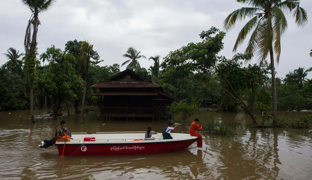 Petugas penyelamat Departemen Layanan Pemadam Kebakaran Myanmar membantu korban banjir menggunakan perahu di kecamatan Mawlamyine, negara bagian Mon, Myanmar (18/6). Banjir di Myanmar Selatan juga mengakibatkan tanah longsor. (AFP PHOTO / Ye Aung Thu)
