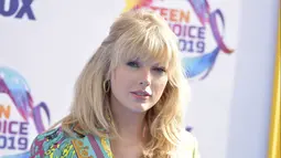 Taylor Swift berpose menghadiri FOX's Teen Choice Awards 2019 di Hermosa Beach, California (11/8/2019). Taylor mengguncang ansambel bermotif Versace yang menampilkan kombinasi kancing baju dan celana pendek yang serasi, yang memperlihatkan bra berenda merahnya. (AP Photo/Richard Shotwell)