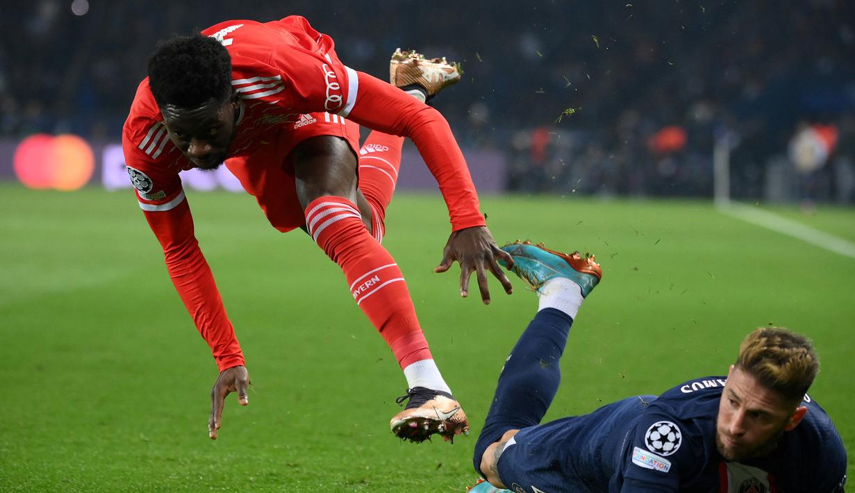 Pemain Bayern Munchen, Alphonso Davies (kiri) dijatuhkan pemain PSG, Sergio Ramos dalam laga leg pertama babak 16 besar Liga Champions 2022/2023 di Parc des Princes Stadium, Paris (14/2/2023). Namun perubahan besar terjadi dalam skema permainan sejak Alphonso Davies dimasukkan. (AFP/Franck Fife)