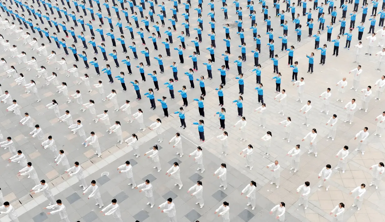 Ribuan orang melakukan pertunjukan bela diri Taichi di salah satu lapangan sekolah di Provinsi Henan, Cina, Minggu (18/10/2015). 50.000 warga Cina ikut serta dalam pertunjukan ini. (REUTERS/Stringer)