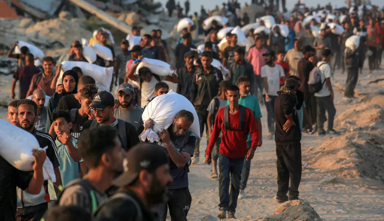 Mereka bergerak cepat menuju lokasi setelah truk pembawa bantuan berhasil masuk ke wilayah tersebut melalui Gerbang Zikim yang dikuasai Israel. (BASHAR TALEB/AFP)