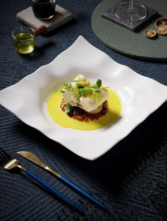 Kreasi ikan baramundi dengan puree kunyit memberikan pengalaman baru yang nikmat dan sehat. Vegetable ratatouille dengan potongan kentang juga membuat perut nyaman. (Foto: Sea Grain Restaurant & Bar)