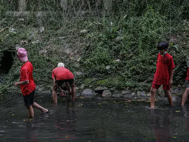 Sejumlah anak-anak mencari belut di anak kali menteng, Jakarta, Selasa (8/6/2021). Ruang bermain anak-anak di Jakarta kian terbatas. Terbatas lahan bermain membuat anak-anak Jakarta bermain ditempat yang tak semestinya demi mencari kesenangan. (Liputan6.com/Faizal Fanani)