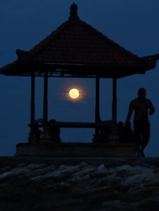 Siluet gazebo terlihat dengan latar belakang supermoon di Pantai Sanur, Bali, Senin (14/11). Fenomena ini terjadi saat bulan mencapai titik terdekat dengan bumi dan merupakan fenomena supermoon terbesar dalam 68 tahun terakhir. (SONNY TUMBELAKA/AFP)