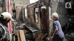 Sejumlah warga membersihkan puing sisa kebakaran yang melanda kawasan Pasar Gembrong, Jakarta, Senin (25/4/2022). Sebanyak  400 Rumah dan Bangunan hangus terbakar dan  total kerugian akibat insiden kebakaran tersebut Ditaksir senilai Rp1,5 Miliar. (Liputan6.com/Faizal Fanani)