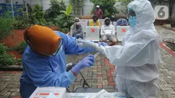 Tenaga kesehatan melakukan persiapan sebelum kegiatan tes swab massal di Puskesmas Ciganjur, Jakarta, Kamis (7/1/2020). Lonjakan kasus virus corona berpotensi terjadinya krisis tenaga kesehatan (nakes) karena banyak yang tertular dan gugur saat menangani pasien Covid-19. (merdeka.com/Arie Basuki)
