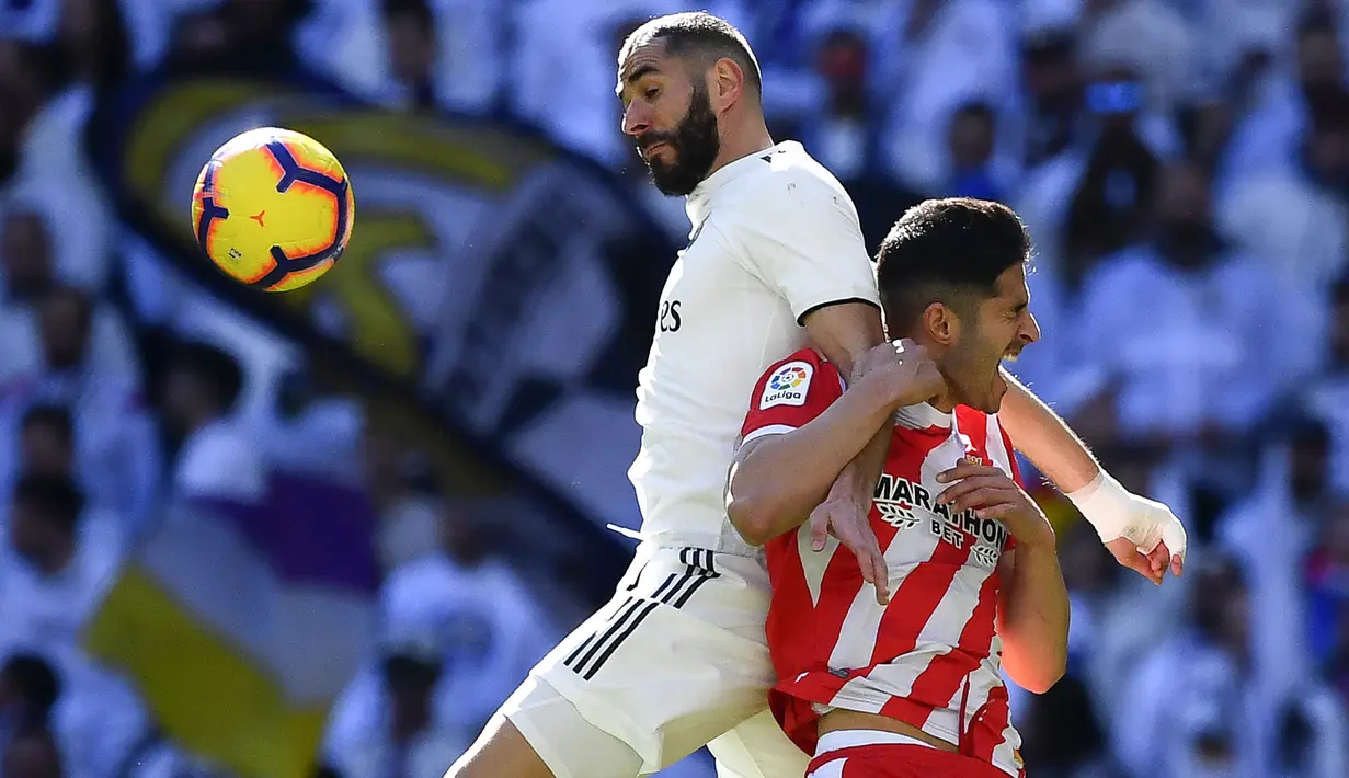 Striker Real Madrid, Karim Benzema, berebut bola dengan bek Girona, Juanpe Ramirez, pada laga La Liga di Stadion Santiago Bernabeu, Madrid, Minggu (17/2). Madrid kalah 1-2 dari Girona. (AFP/Gabriel Bouys)