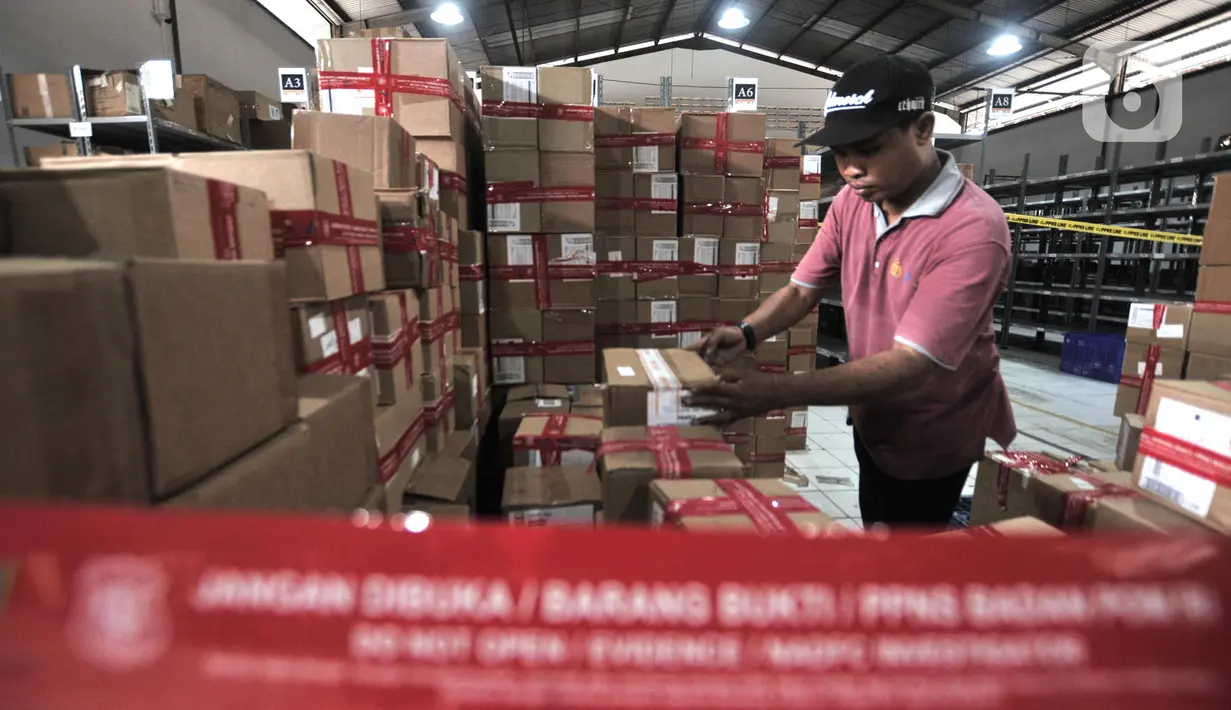 Petugas PPNS BPOM memeriksa barang bukti hasil pengungkapan kasus peredaran obat dan makanan ilegal di sebuah gudang kawasan Sunter, Jakarta, Selasa (10/12/2019). BPOM menyita 43.071 kosmetik, 58.355 obat tradisional, dan 14.533 pangan olahan ilegal senilai Rp 53 miliar. (merdeka.com/Iqbal Nugroho)
