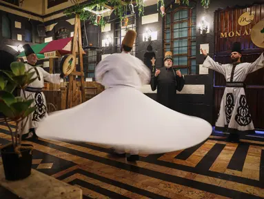 Para penari berputar menampilkan tarian Sufi di sebuah restoran selama pertunjukan yang diadakan setelah berbuka puasa selama bulan suci Ramadan 1447 Hijriah, di distrik bersejarah Damaskus, Suriah, Minggu 22 Februari 2026. (AP Photo/Ghaith Alsayed)
