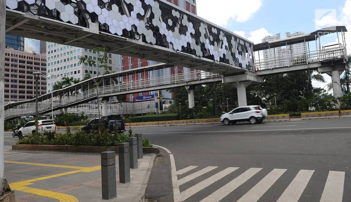 Kendaraan melintas di Jalan Jenderal Sudirman, Jakarta, Jumat (4/1). Jembatan penyeberangan orang (JPO) Dukuh Atas saat ini sudah bisa dilintasi pejalan kaki. (Liputan6.com/Herman Zakharia)