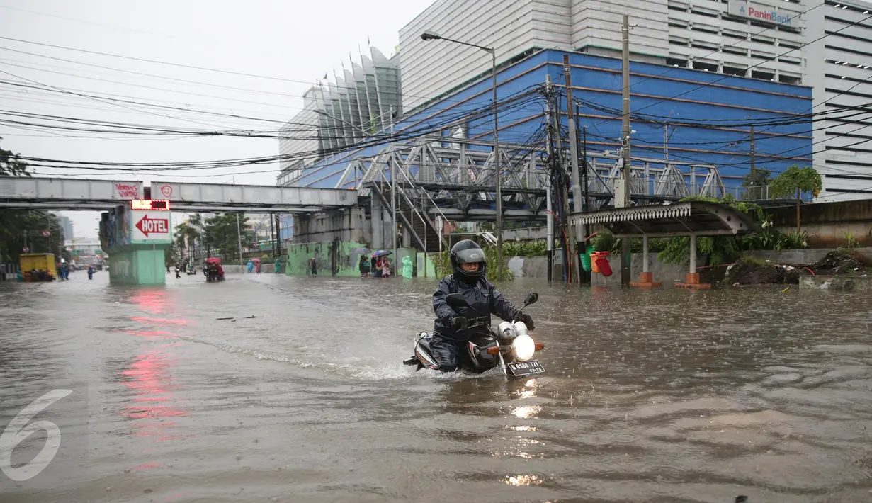 Pengendara motor menerobos banjir yang menggenangi Jalan Gunung Sahari, Pademangan, Jakarta Pusat, Selasa (21/2). Banjir setinggi pinggang orang dewasa menyebabkan terputusnya sejumlah akses jalan untuk kendaraan bermotor. (Liputan6.com/Faizal Fanani)
