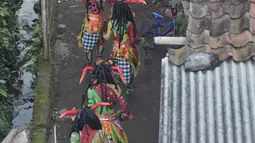 Para penari menuju tempat pentas Festival Lima Gunung di lereng Gunung Merapi, Desa Klogowanan, Magelang, (21/7). Festival tersebut diselenggarakan secara mandiri oleh petani setiap tahun. (Liputan6.com/Gholib)