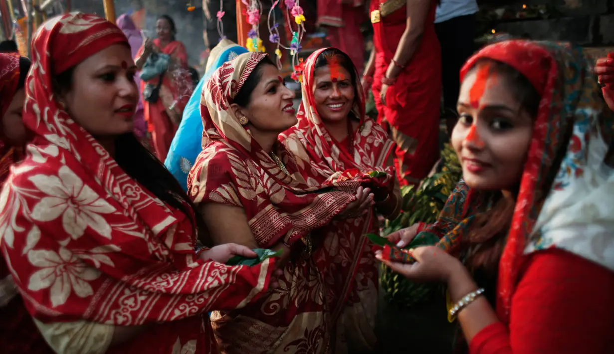 Sejumlah wanita Nepal mengikuti festival Chhath Puja di tepi Sungai Bagmati, Kathmandu, Nepal (26/10). Festival ini dilakukan untuk berterima kasih kepada Dewa Matahari. (AP Photo/Niranjan Shrestha)