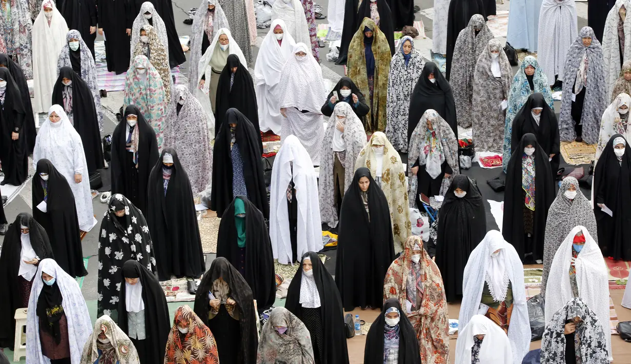 Umat muslim menerapkan jaga jarak aman sebagai langkah pencegahan penularan virus corona COVID-19 saat melaksanakan salat Idul Fitri di Teheran, Iran, Minggu (24/5/2020). Iran melonggarkan kebijakan lockdown untuk mencegah penyebaran virus corona COVID-19. (Photo by - / AFP)