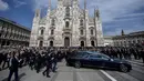 <p>Kerumunan massa mengibarkan bendera klub sepak bola AC Milan sambil meneriakkan "Silvio, Silvio" saat peti matinya dibawa ke dalam Katedral Gotik Milan. Peti mati Berlusconi dikawal oleh polisi Carabinieri. (Claudio Furlan/LaPresse via AP)</p>