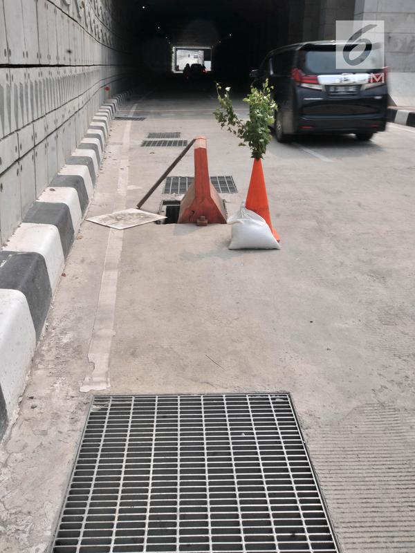 Cone block dan tanaman diletakkan dekat penutup lubang saluran air yang hilang di Underpass Mampang-Kuningan, Jakarta, Kamis (23/8). Tak ada petugas keamanan dari pihak Pemprov DKI atau Kepolisian yang berjaga di kawasan ini (Merdeka.com/Iqbal S. Nugroho)