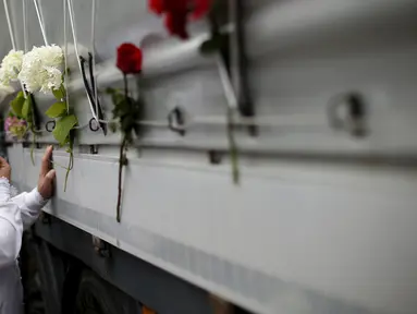 Wanita menangis di depan sebuah truk yang membawa 136 korban yang baru diidentifikasi di desa Visoko, Bosnia-Herzegovina, Kamis, (9/7/2015). Para Jenazah akan diangkut ke pusat peringatan di Potocari.(REUTERS/Stoyan Nenov)