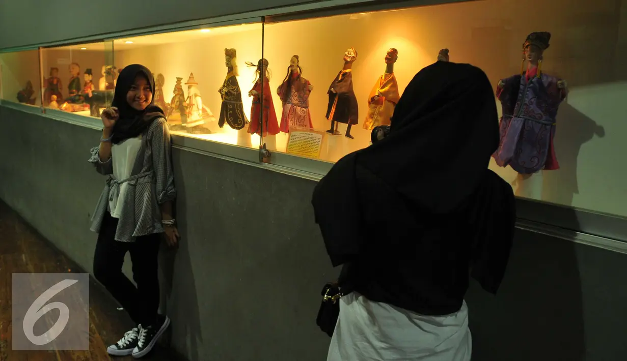 <p>Pengunjung berpose di dekat koleksi Museum Wayang, Jakarta, Jumat (8/7). Setidaknya terdapat 4.000 koleksi wayang dari dalam maupun luar negeri tersimpan di museum tersebut. (Liputan6.com/Gempur M Surya)</p>