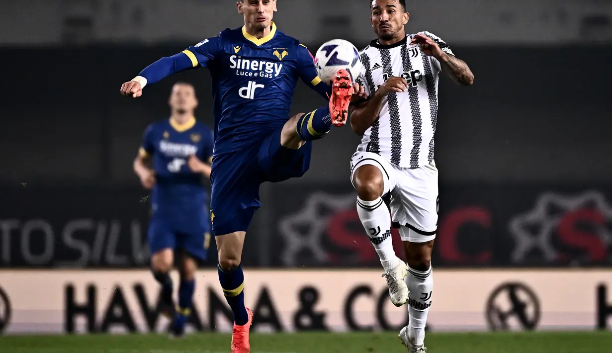 Penyerang Verona, Kevin Lasagna (kiri) berebut bola dengan bek Juventus, Danilo selama pertandingan lanjutan Liga Serie A Italia di stadion Bentegodi di Verona, Jumat (11/11/2022). Juventus menang tipis atas Verona dengan skor 1-0. (AFP/Marco Bertorello)