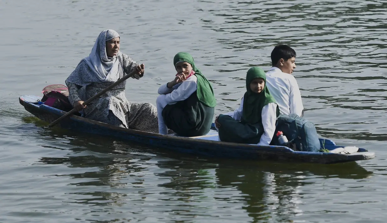 <p>Seorang perempuan mendayung perahu selama jam sekolah di Danau Dal di Srinagar, India, Rabu (11/5/2022). Danau terbesar di negara bagian tersebut penting untuk kegiatan perikanan, perairan, rekreasi, dan pariwisata. (TAUSEEF MUSTAFA / AFP)</p>