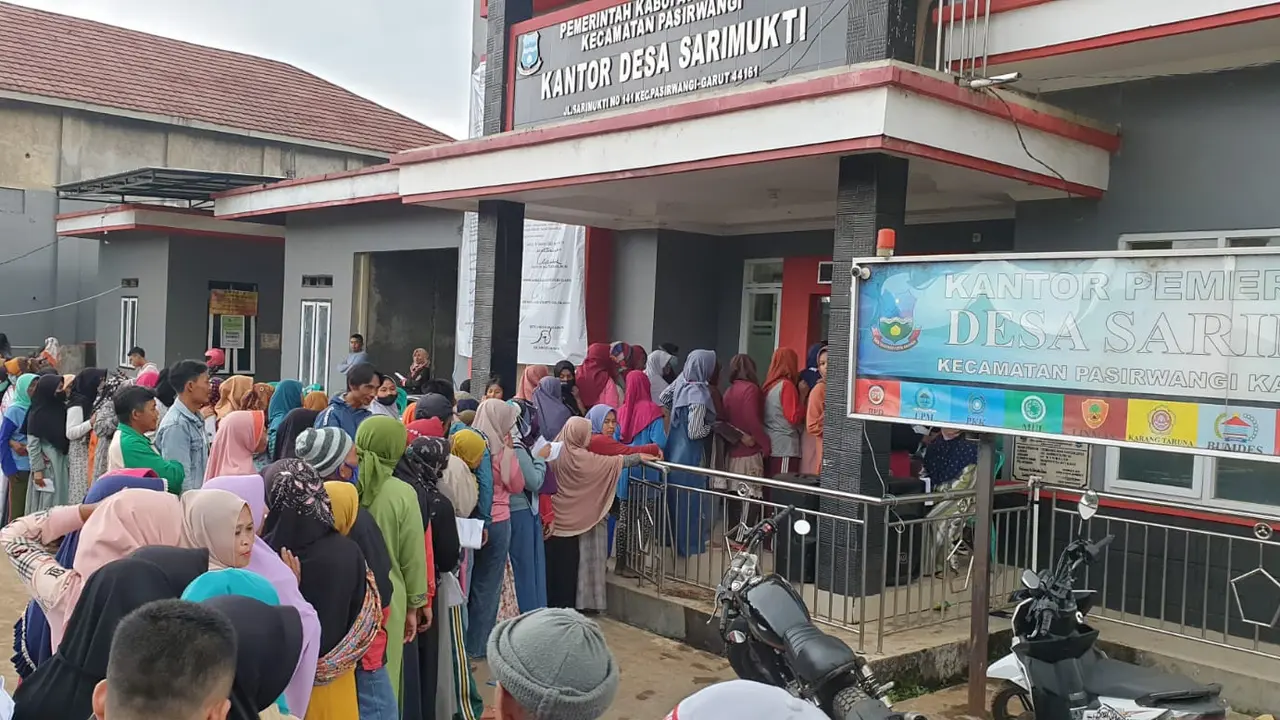 Antrian KPM penerima bantuan BLT minyak goreng di depan desa Sarimukti, Kecamatan Pasirwangi Garut, Jawa Barat