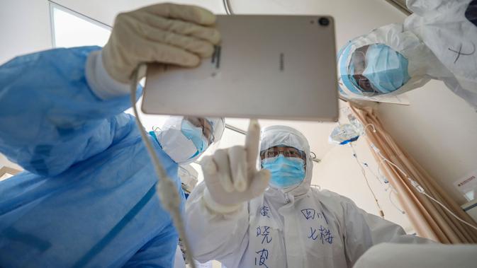 Dokter melihat gambar saat memeriksa pasien yang terinfeksi virus corona (Covid-19) di Rumah Sakit Palang Merah di Wuhan, 16 Februari 2020. Jumlah korban meninggal akibat virus corona (Covid-19) di seluruh dunia hingga Minggu (8/3) pagi sudah mencapai 3.570 orang, terbanyak masih di China. (STR/AFP)