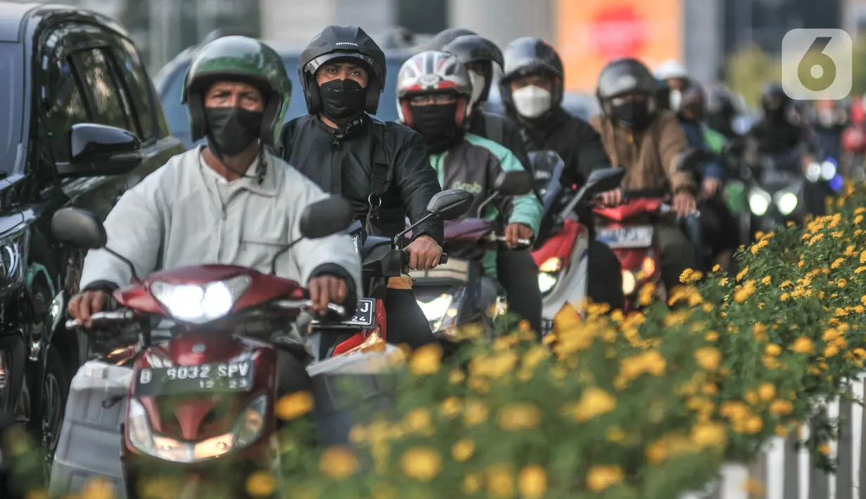 Pengendara sepeda motor melintas di Jalan Jenderal Sudirman, Jakarta, Selasa (4/1/2022). Pemberlakuan pembatasan kegiatan masyarakat (PPKM) Jakarta kembali diperpanjang oleh pemerintah pusat terhitung 4-17 Januari 2022 dari sebelumnya di Level 1 kini menjadi Level 2. (merdeka.com/Iqbal S. Nugroho)