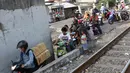 Pengendara sepeda motor melintasi jalan setapak di pinggir rel kereta di kawasan Tambora, Jakarta, Senin (10/7). Tidak tersedianya akses jalan untuk putar balik membuat warga terpaksa memanfaatkan jalan setapak tersebut. (Liputan6.com/Immanuel Antonius)