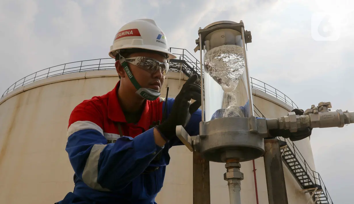 Petugas melakukan pengecekan berkala kualitas bahan bakar avtur pada Instalasi Depot Pengisian Pesawat Udara (DPPU) Soekarno-Hatta Fuel Terminal & Hydrant Installation (SHAFTHI) di kawasan Bandara Soekarno-Hatta, Tangerang, Banten, Selasa (2/10/2024). (Liputan6.com/Herman Zakharia)