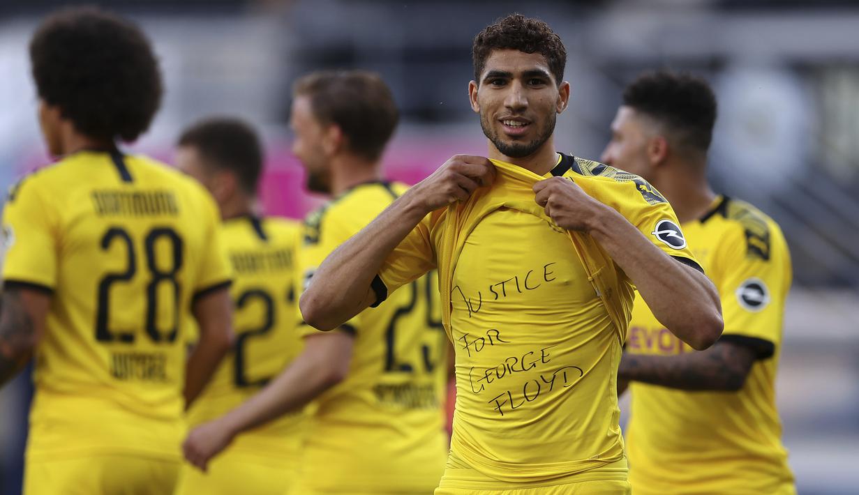 Pemain Borussia Dortmund, Achraf Hakimi, menunjukan tulisan rasa simpati untuk mendiang George Floyd saat melawan SC Paderborn 07 pada laga Bundesliga di Stadion Benteler, Minggu (31/5/2020). Borussia Dortmund menang dengan skor 6-1 SC Paderborn 07. (AP/Lars Baron)