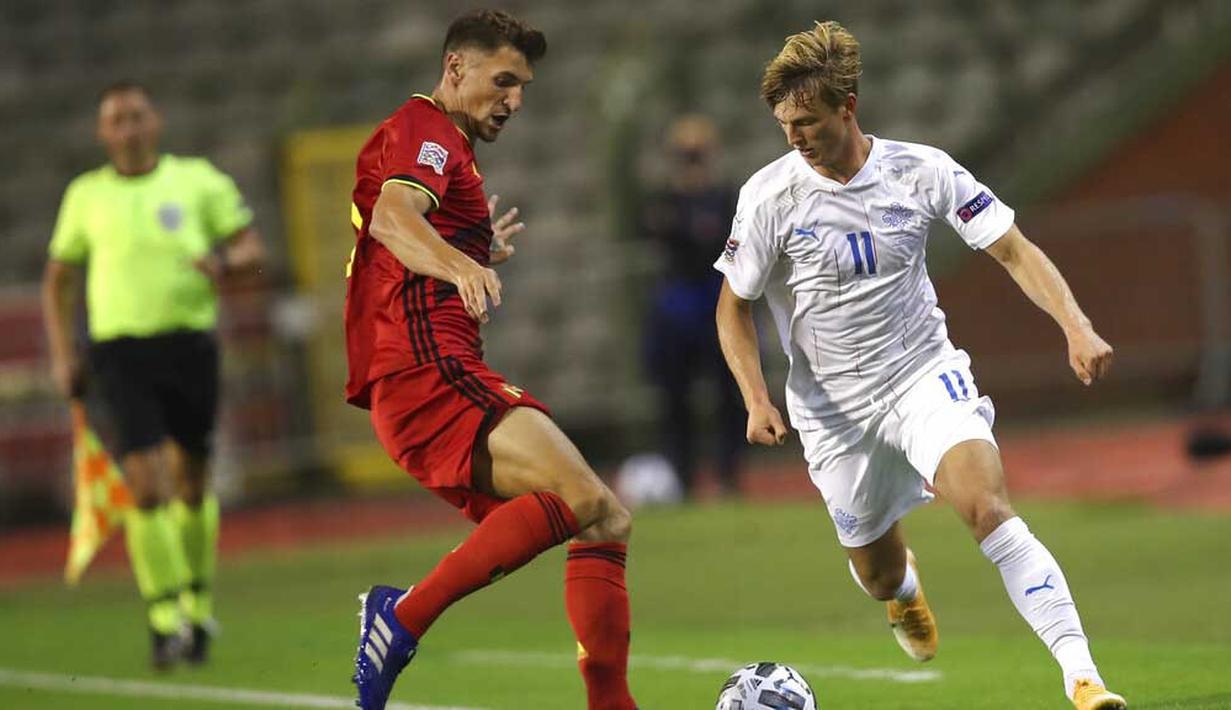 Pemain Belgia, Thomas Meunier, berebut bola dengan pemain Islandia, Albert Gudmundsson, pada laga UEFA Nations League di Stadion King Baudouin, Rabu (9/9/2020). Belgia menang telak dengan skor 5-1. (AP/Francisco Seco)